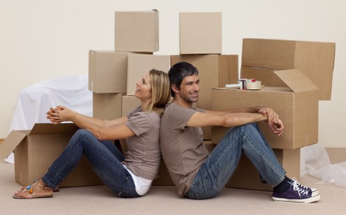 Local moving team handling boxes near an Elephant and Castle apartment building